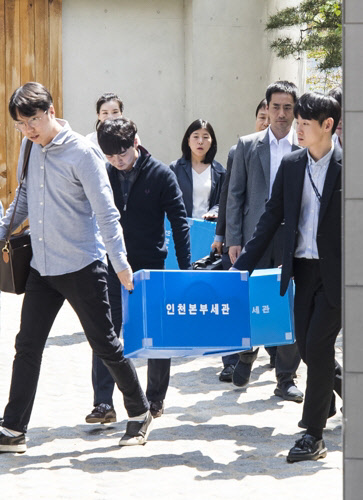 관세청이 23일 관세포탈 혐의를 받고 있는 한진그룹 총수 일가 조사를 위해 지난 주말에 이어 두 번째 압수수색을 진행했다. 지난 21일 관세청 관계자들이 조현민 전 대한항공 전무와 조현아·원태 3남매 등 한진그룹 총수일가의 자택에서 압수수색 물품을 들고 나서고 있다. <연합뉴스>.